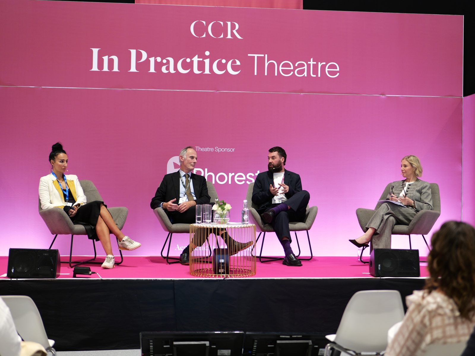 A four-person panel on the CCR In Practice Theatre stage, photographed by Kyros